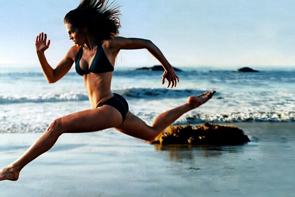 Девушка бежит по побережью моря