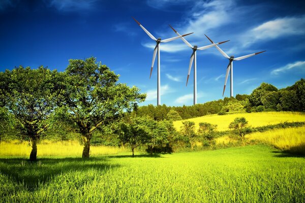 Три ветряных генератора на холме среди зелени