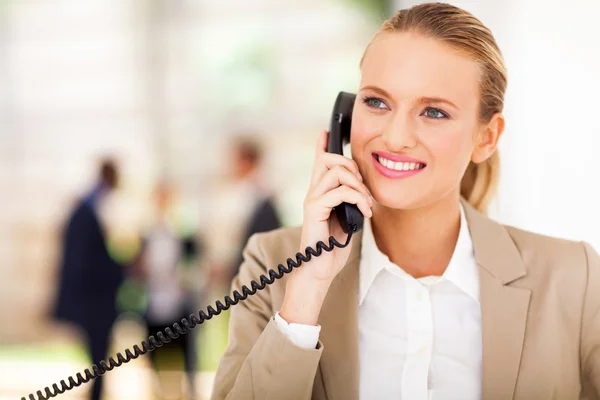 Счастливый женский офисный работник говорить на стационарный телефон — стоковое фото