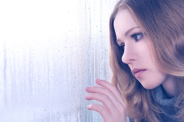 Печаль девушка у окна в дождь Лицензионные Стоковые Фото