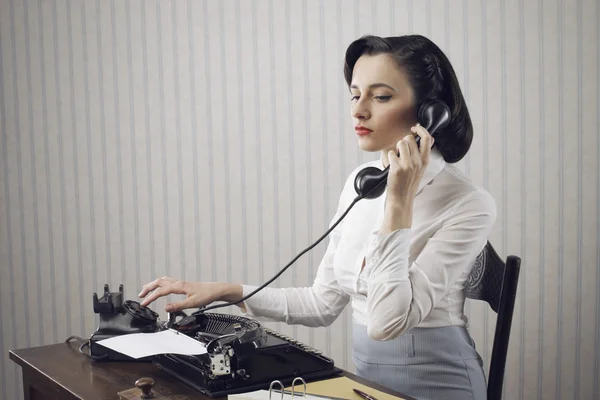 Женщина, говоря на телефоне на стол Стоковое Изображение