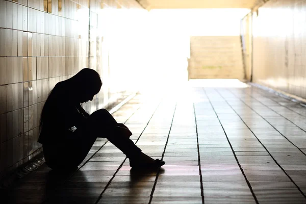Подростковая депрессия сидя внутри грязный туннель Стоковая Картинка