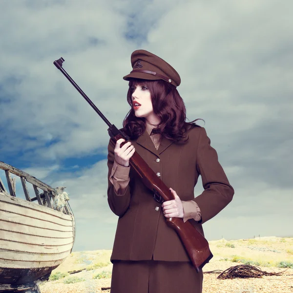 Привлекательная женщина в армейской форме, носящей винтовку Стоковое Изображение