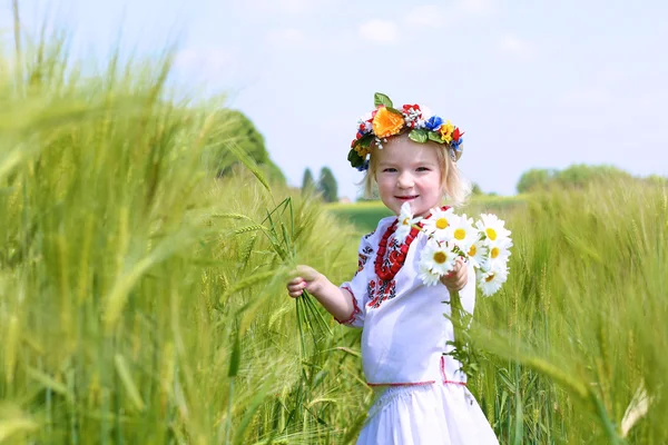 Маленькая девочка в украинскую одежду, играя в поле — стоковое фото