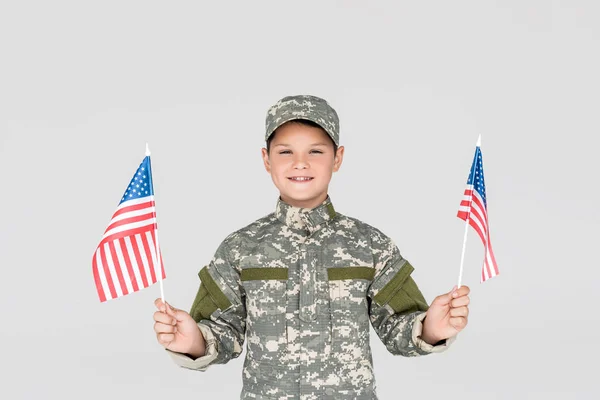 Portrait Smiling Child Military Uniform American Flagpoles Hands Isolated Grey — стоковое фото