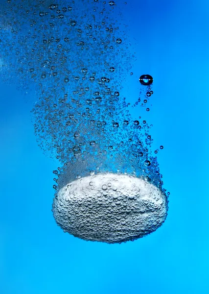 Шипучая таблетка в воде с пузырь — стоковое фото
