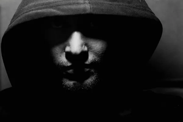 Monochrome picture of a guy in a hood — стоковое фото