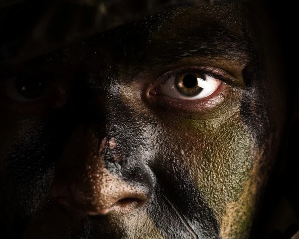 Молодой солдат лицо в камуфляжной краске — стоковое фото