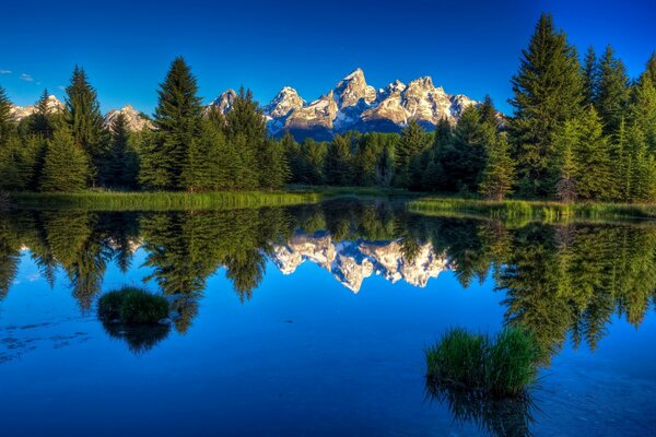 Горы, отражающие в спокойной голубое озеро