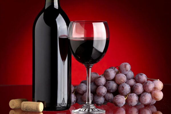Красное вино, бокал и гроздь винограда