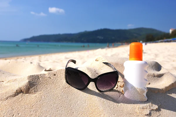 Солнцезащитные очки и лосьон на песчаном пляже острова Пхукет, thail Стоковое Изображение