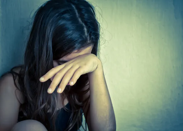 Одинокая девочка, кричащая рукой, закрывающей ее лицо — стоковое фото