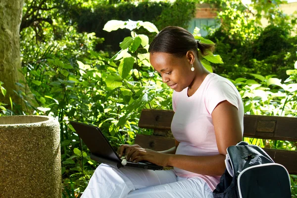 Женский Африканский студент с помощью ноутбука на открытом воздухе — стоковое фото