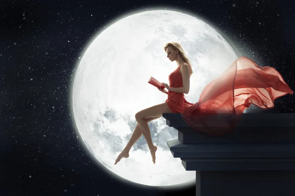 Симпатичная женщина на фоне полной Луны — стоковое фото