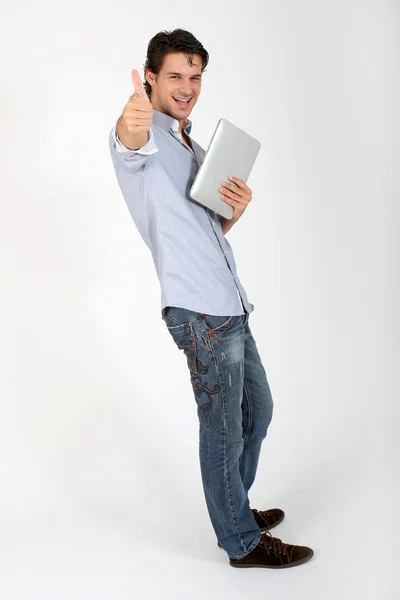 Молодой человек в синие джинсы, показывая большой палец вверх — стоковое фото