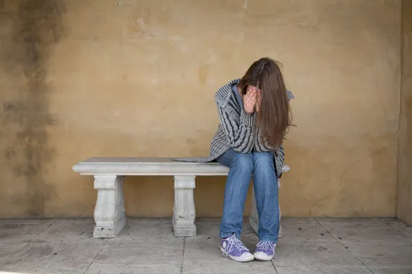 Одинокая женщина плачет на скамейке — стоковое фото