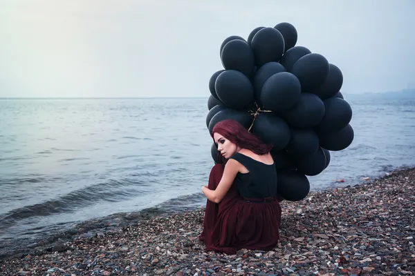 Красивая девушка, ходьба с черные шары — стоковое фото