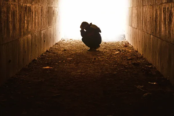Беспризорный, сидя в тоннель в горе — стоковое фото