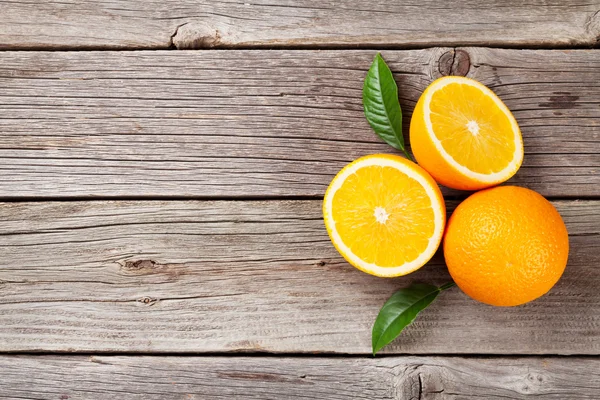 Свежие апельсины на деревянный стол — стоковое фото