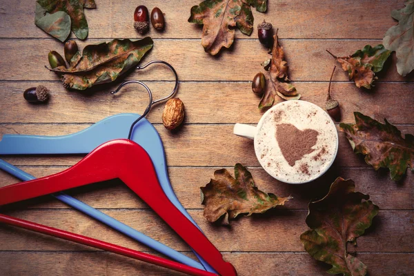 Вешалки, чашка кофе и опавшие листья Стоковая Картинка