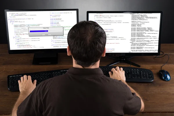 Человек программирование кода на компьютерах — стоковое фото