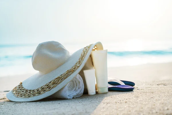 Крем для загара, шляпа с сумкой на тропическом пляже Стоковое Фото