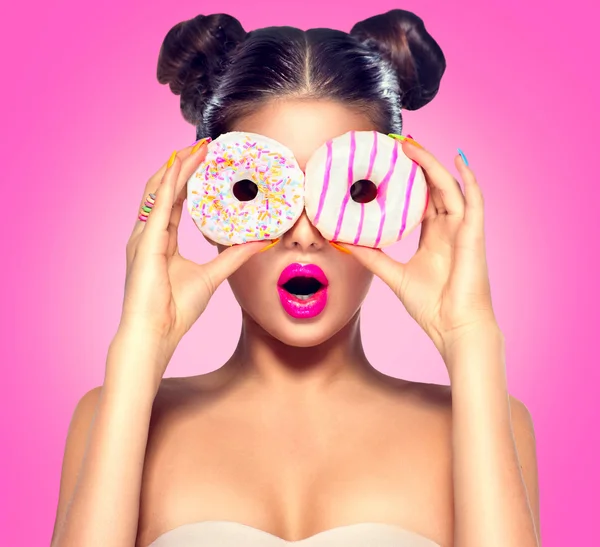 Девушка принимая красочные пончики — стоковое фото