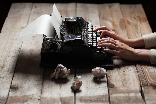 Руки, перезаписывая деревянный стол фон на старая пишущая машинка — стоковое фото