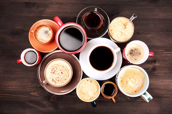 Многие чашки кофе на деревянный стол — стоковое фото
