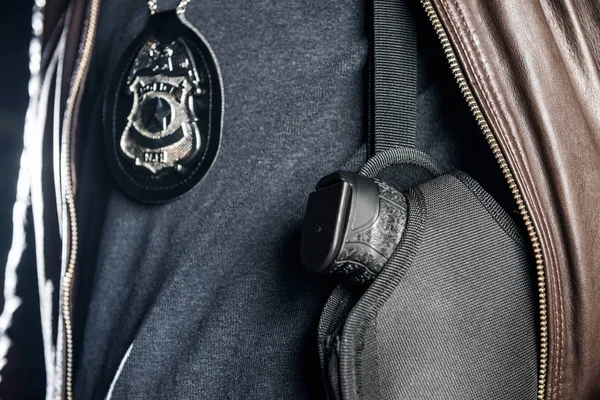 Офицер с знак и пистолет — стоковое фото