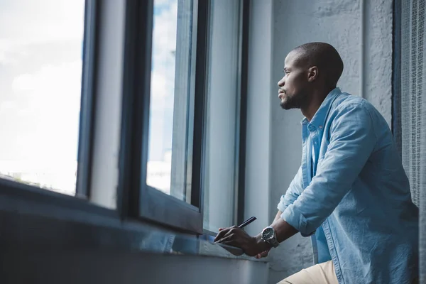 African american man looking at window — стоковое фото
