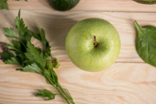 Яблоко с петрушкой на деревянном столе — стоковое фото