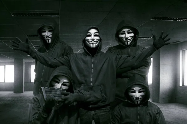 Хакеры в масках с клавиатурой — стоковое фото