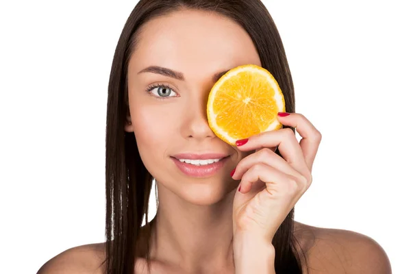 Женщина, охватывающих глаз с ломтик апельсина — стоковое фото