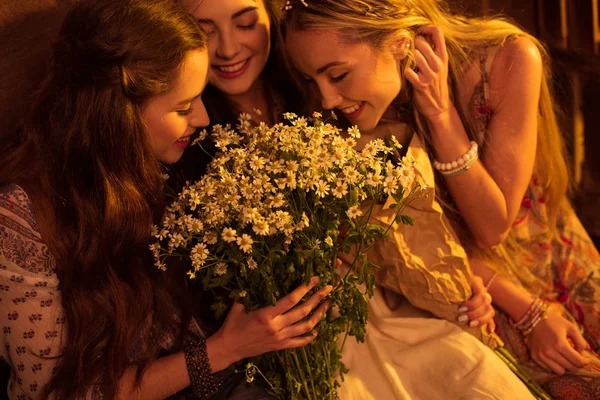 Women in boho style smelling flowers — стоковое фото