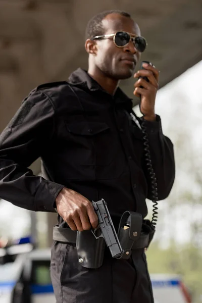 Сотрудник Полиции Говорят Радио Рацию Удерживая Пистолет — стоковое фото