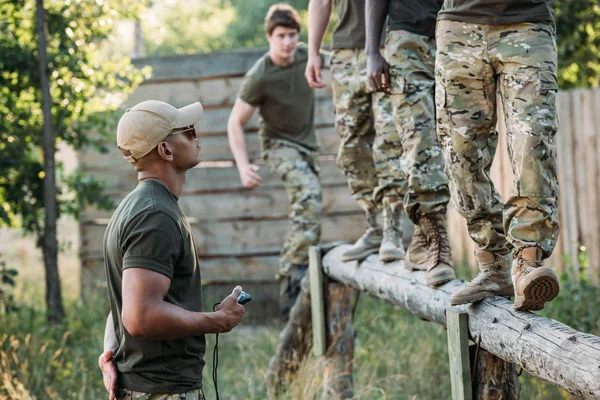 Tactical Instructor Stop Watch Examining Multiracial Soldiers Obstacle Run Range — стоковое фото