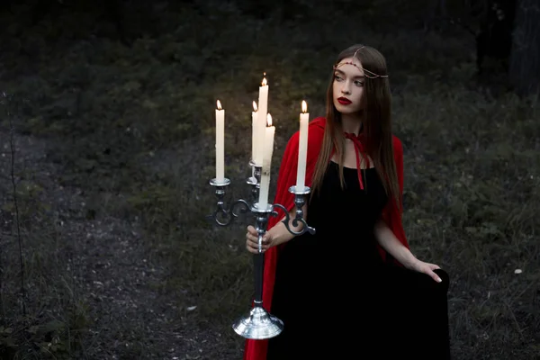 Elegant Mystic Girl Red Cloak Holding Candelabrum Flaming Candles Walking — стоковое фото