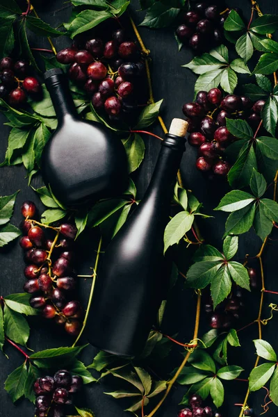 Top View Fresh Ripe Grapes Green Leaves Bottles Wine Dark — стоковое фото