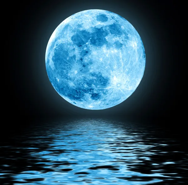 Полная Голубая Луна над водой с отражениями — стоковое фото
