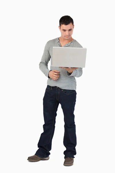 Молодой мужчина, глядя на экран ноутбука — стоковое фото